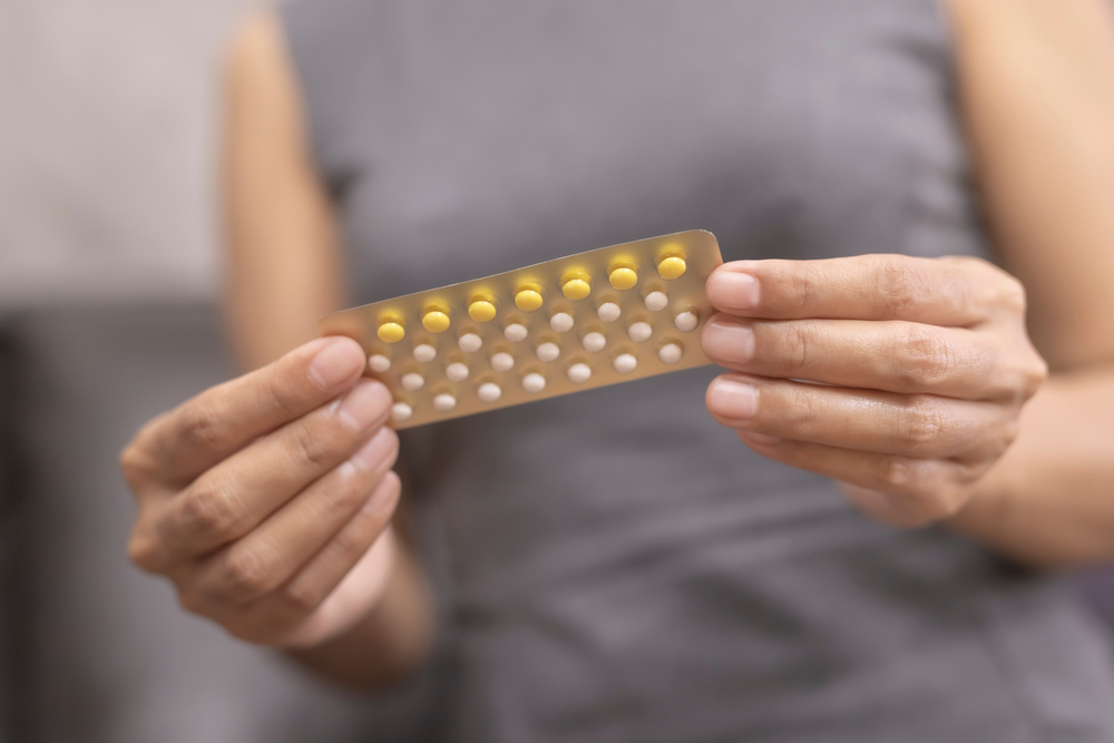 woman with an oral contraceptive packet