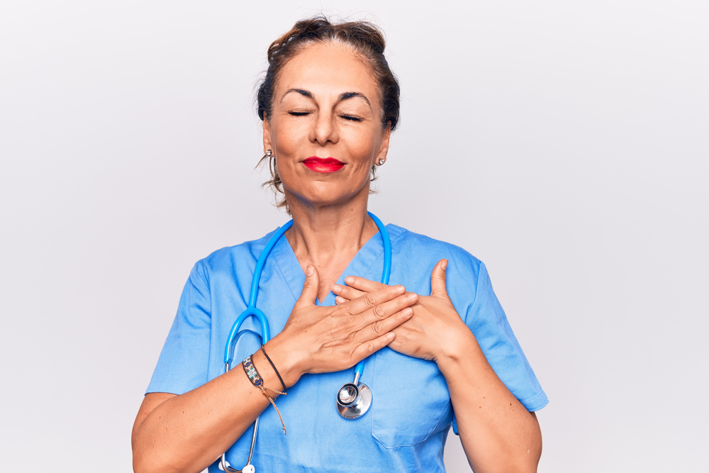 Nurse showing gratitude with her hands over her heart