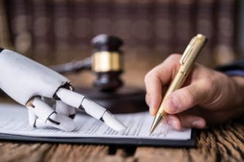 A robotic hand points to a paper along with a human hand with a pen to illustrate AI for writing